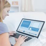 Жена проверява профила в социалните мрежи с лаптопа си