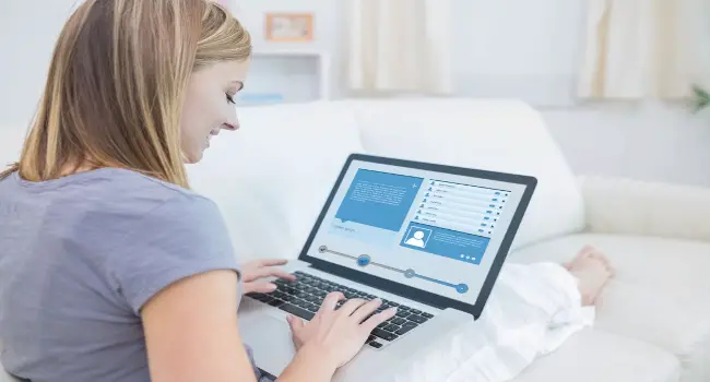Mujer comprobando el perfil de las redes sociales con su computadora portátil