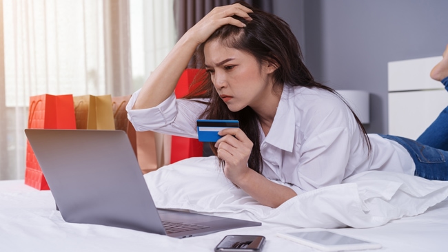 Donna stressata che utilizza il computer portatile per lo shopping online