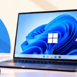 Laptop running Windows 11 with the Bloom wallpaper, the Windows logo and the centered taskbar